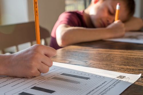 Child writing on white paper 