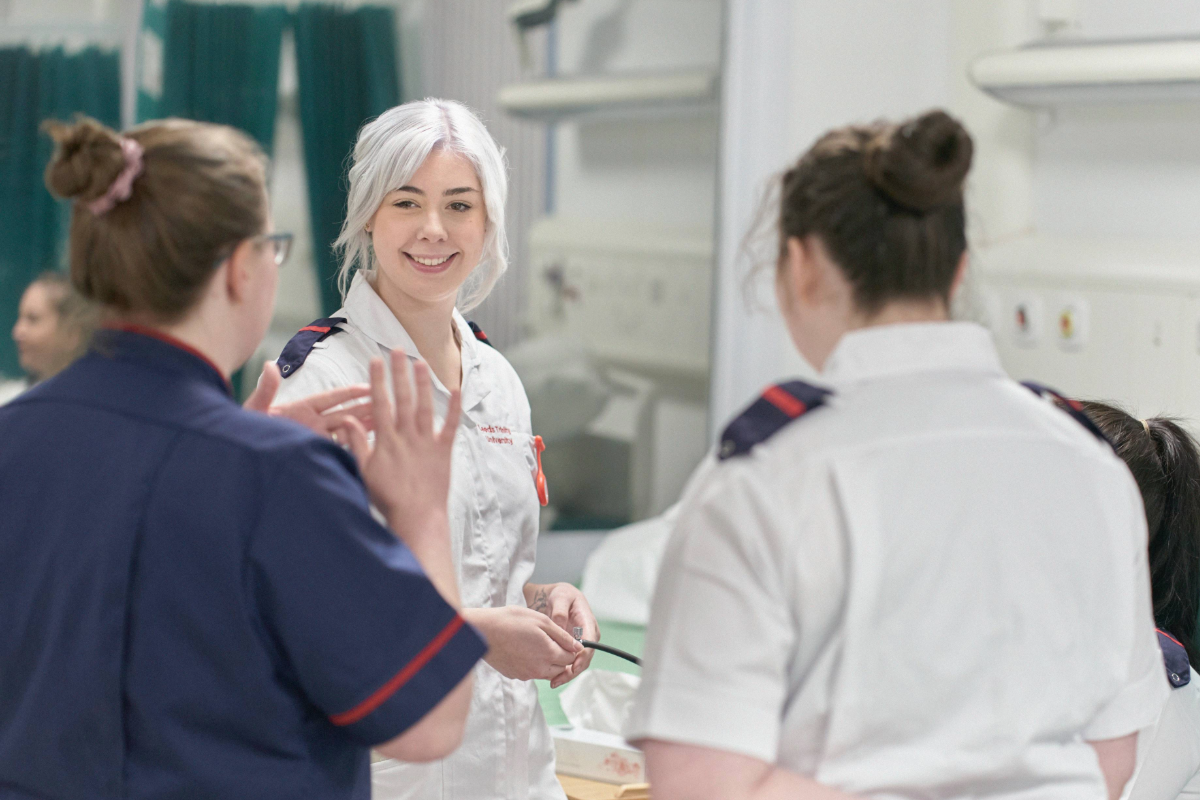 Nursing student smiling at Nursing lecturer and working in our Nursing facilities