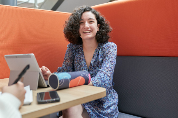 Student smiling and working on laptop