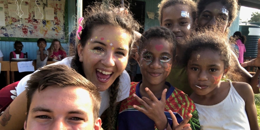 Female student brown hair with school children in Fiji wearing glitter