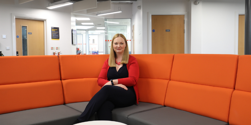 Lady with blond hair sat on sofa