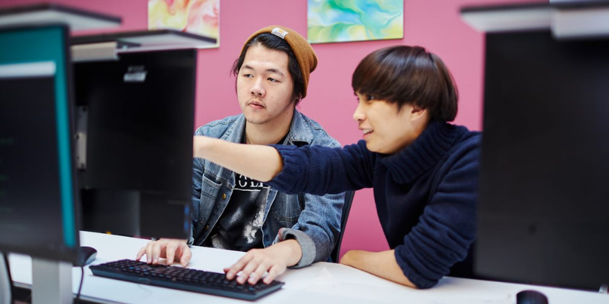 Two male students sat at computer screen
